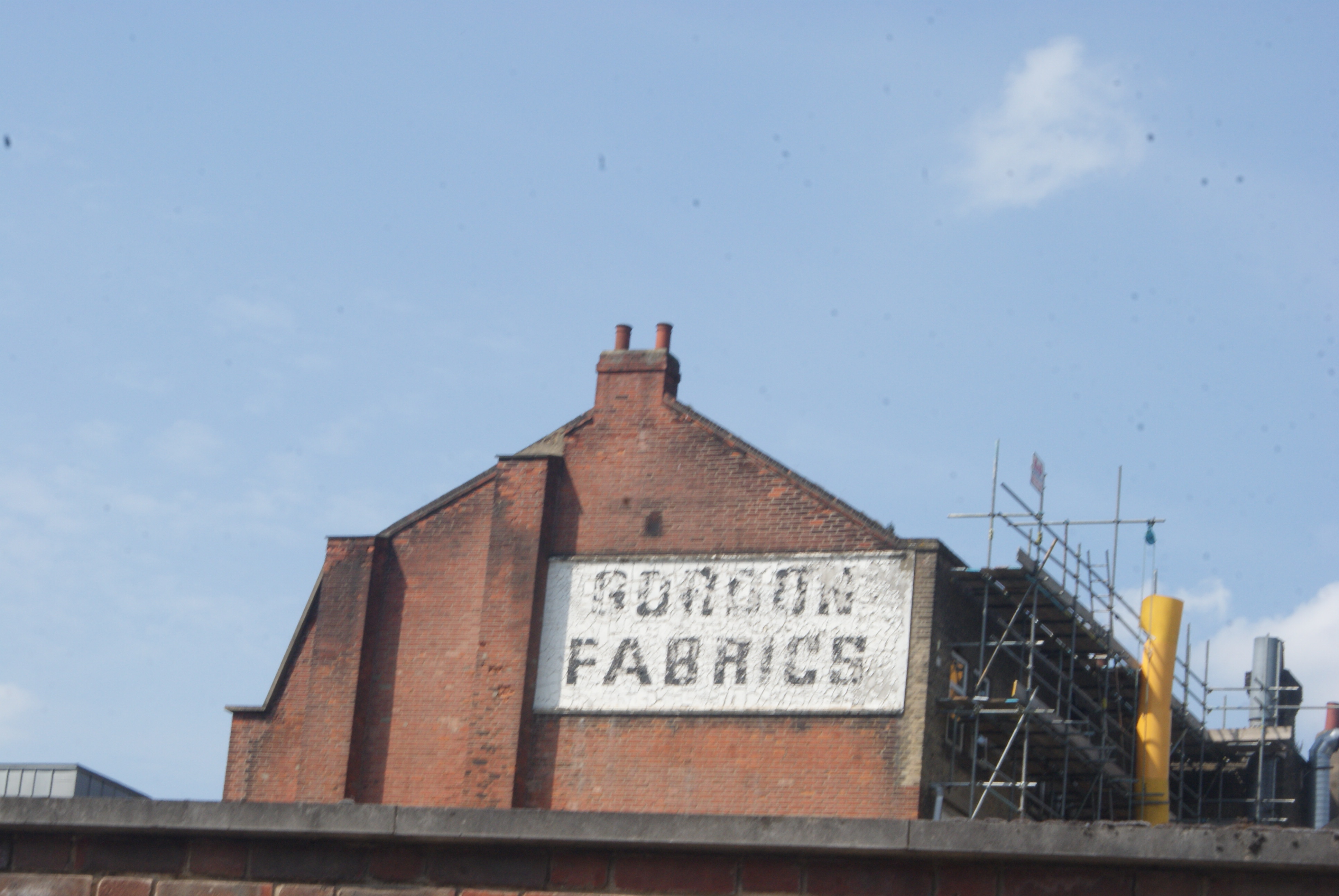 Faded Gordon Fabrics painted sign on brickwork in Hackney, London