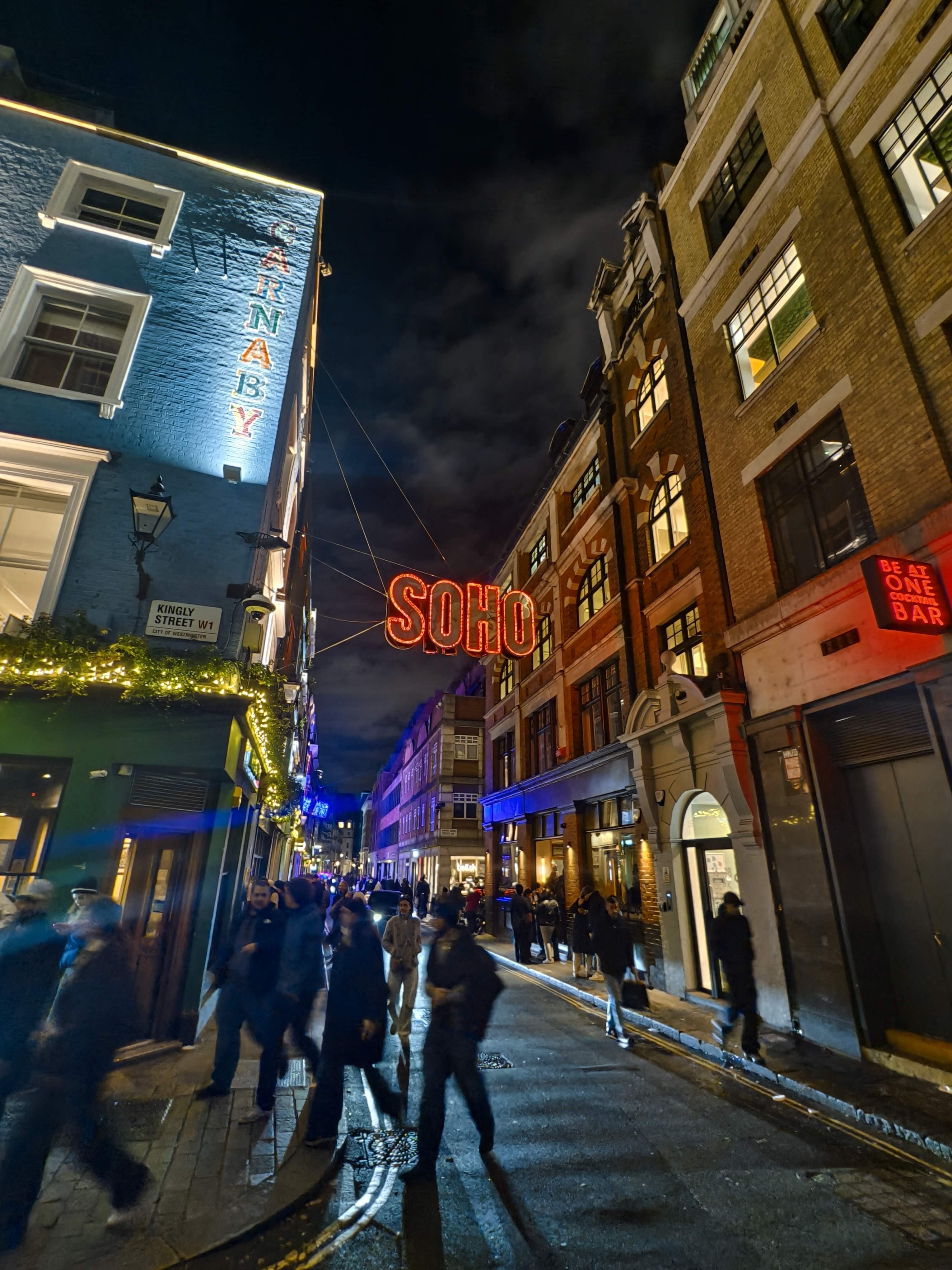 Orange SOHO neon suspended above Kingly Street, London